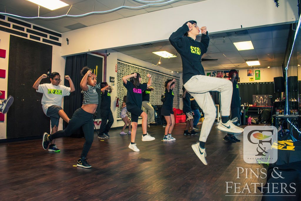 Dance students practicing a jump combination